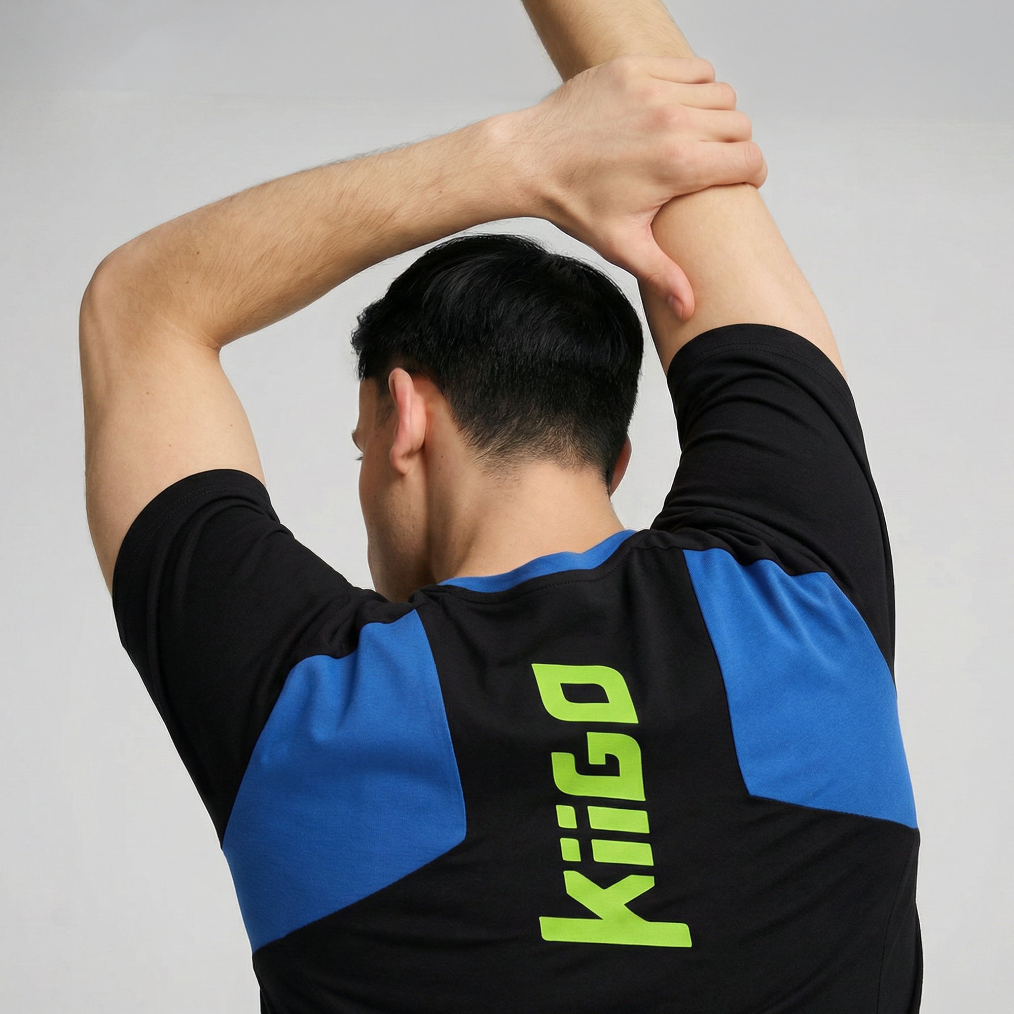 Herren Sport T-Shirt Schwarz mit Blau-Einsatz – Rückseite getragen beim Dehnen
