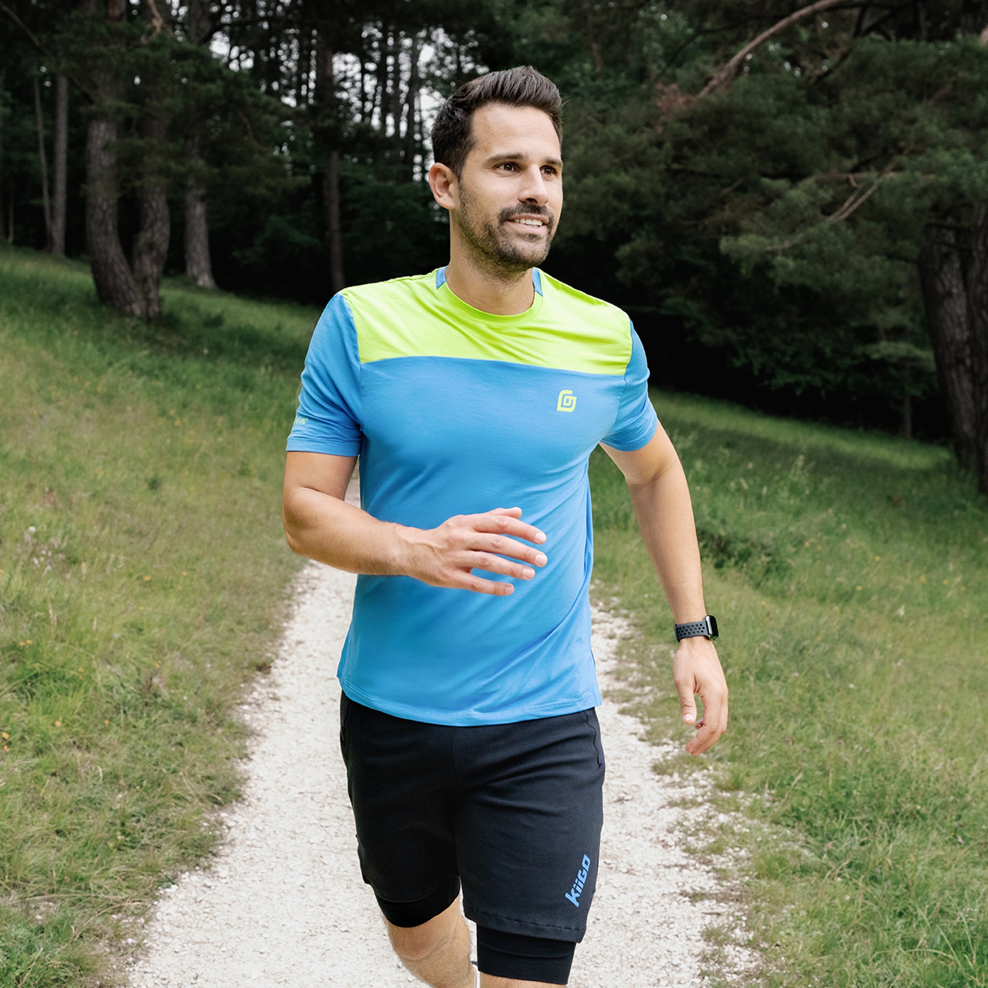 Herren T-Shirt Blau mit Lime-Schulter – getragen beim Laufen im Wald